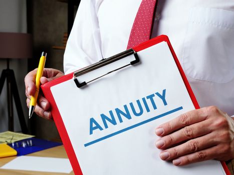 Person holding a clipboard that says the word Annuity